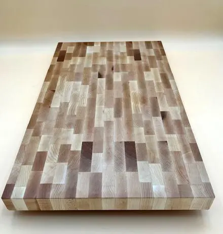 A hand crafted MAPLE BUTCHER BLOCK CUTTING BOARD MEDIUM with squares on it.