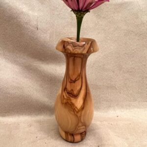 An OLIVE WOOD VASE with a pink flower in it.
