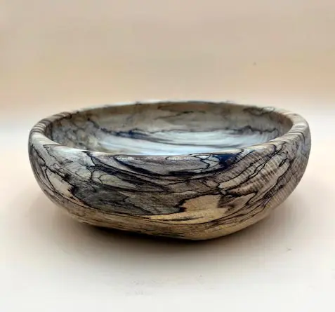 A Hackberry Salad Bowl with a black and white pattern on it.