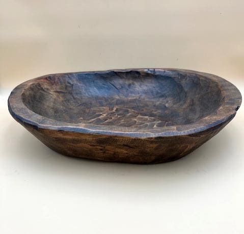 A large CARVED DOUGH BOWL.
