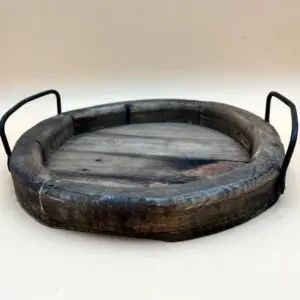 A ROUND RECLAIMED WOODEN TRAY with metal handles.