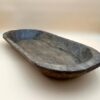 An oval shaped LARGE CARVED DOUGH BOWL on a white surface.