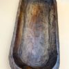 A large carved LARGE CARVED DOUGH BOWL on a white surface.