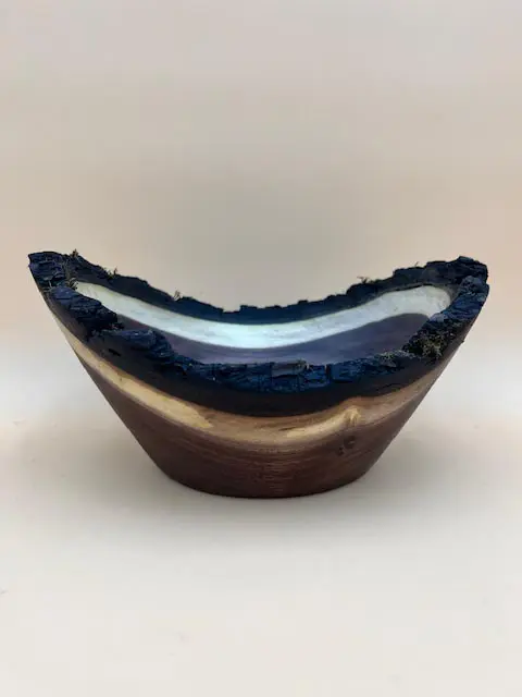 Wooden bowl with black and purple streaks.